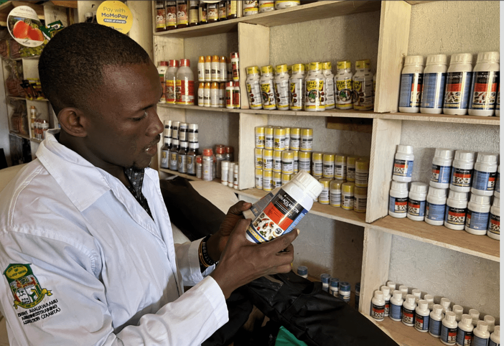 A man reading the label of a pesticide products in an agro-dealer shop