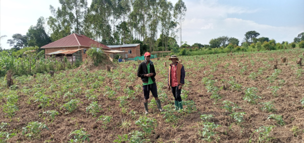 Anthony and a farmer in a field.
